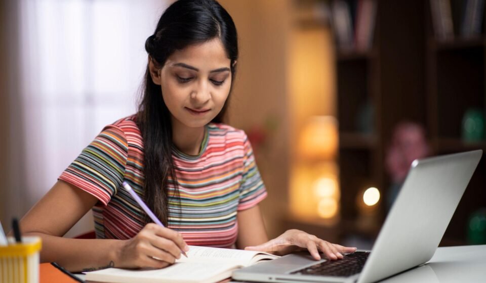 Student studying with a planner, books and laptop at a desk while following a balanced study routine